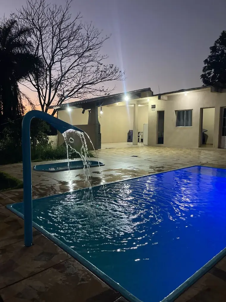 Piscina e área coberta da unidade Status à noite